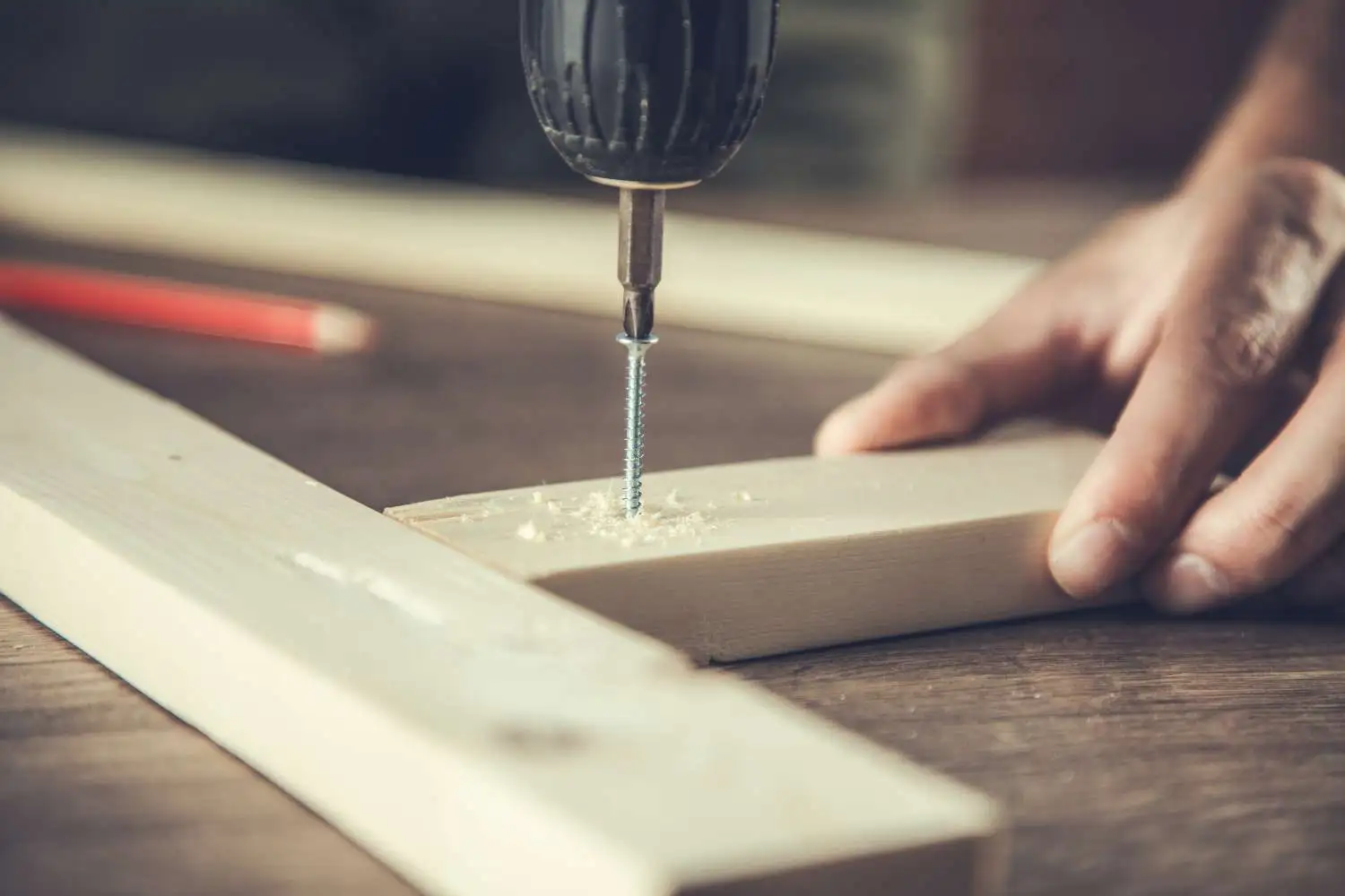 Using a Cordless Drill to insert a screw into wood.